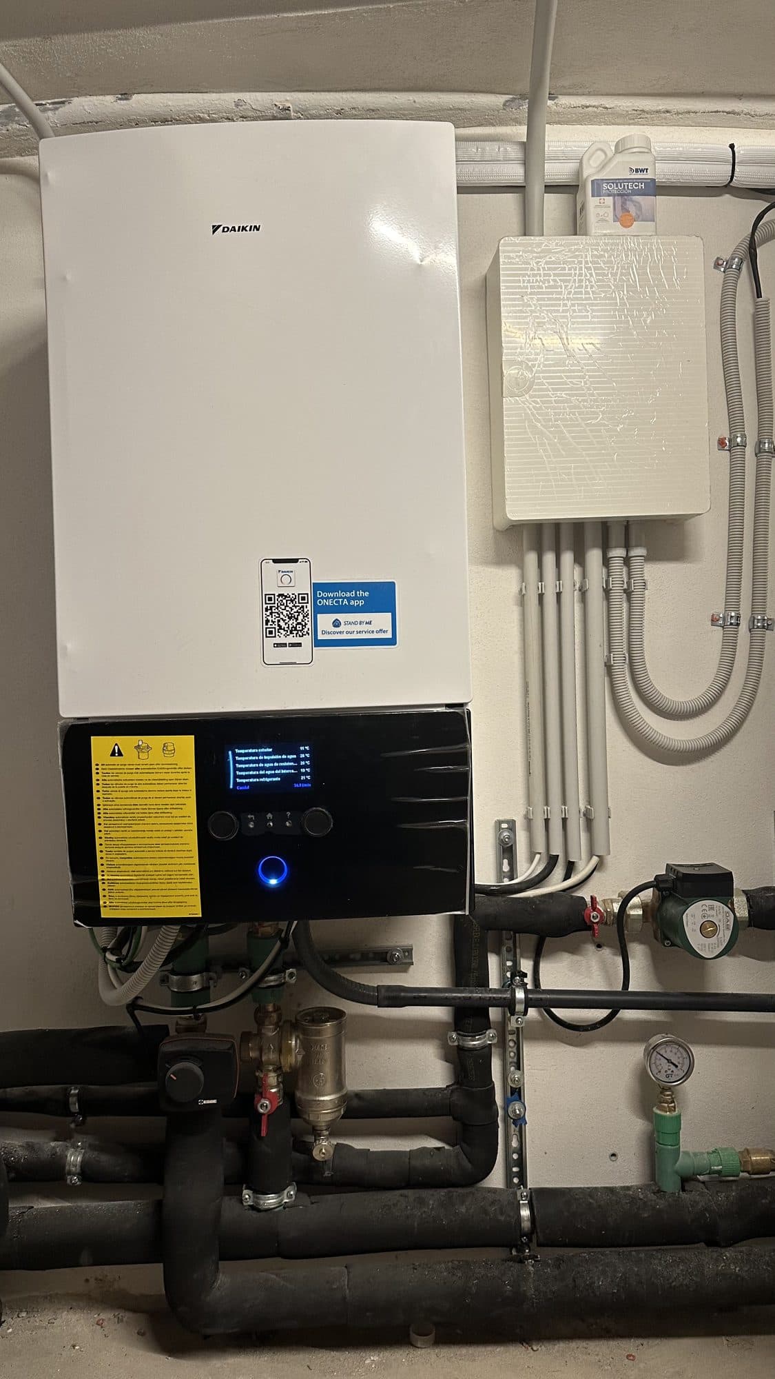 Wall-mounted heat pump hydraulic module with circulation pump, filter and insulated pipes